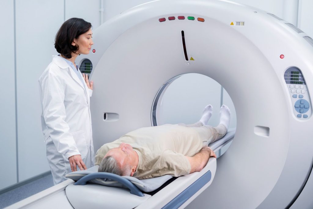 Patient receiving a CT scan at cheap diagnostic imaging centers in Houston, monitored by a healthcare professional.