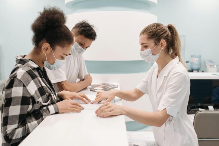 A friendly receptionist assists a couple at the front desk of a top-rated self referral ultrasound centers in Houston.