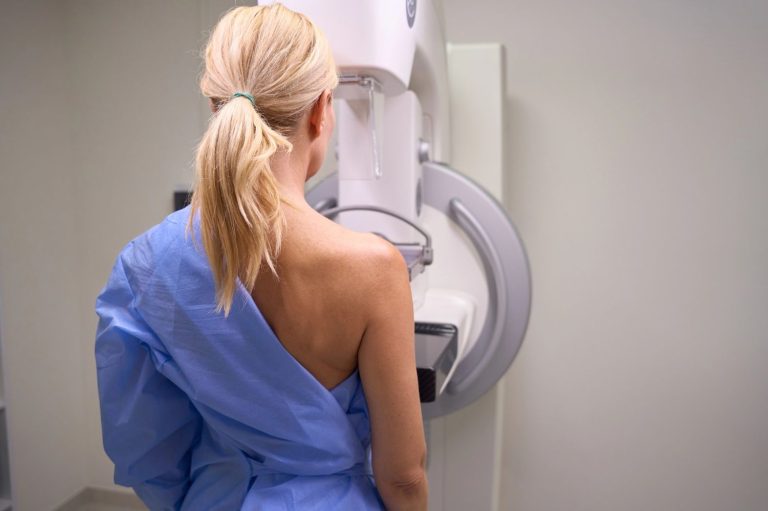Woman in blue gown undergoing a 3D mammograms Houston procedure, ensuring early breast cancer detection.