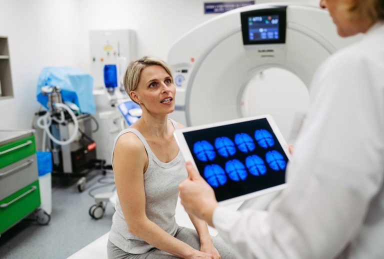Houston patient consults with technician after cheap CT scan, reviewing brain imaging results for diagnosis.