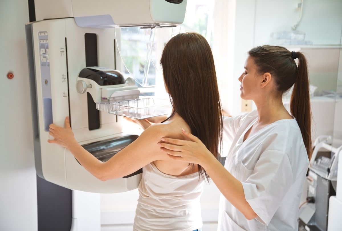 3D mammogram in Houston clinic with technician guiding patient for accurate breast imaging and cancer screening.