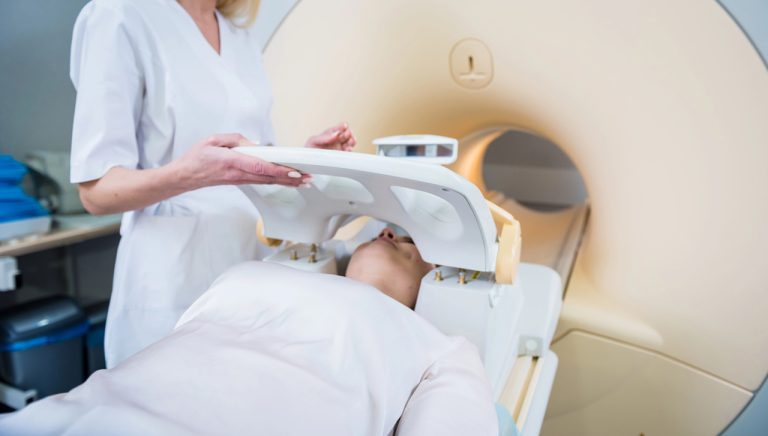 Healthcare professional positioning patient for head CT scan in modern radiology facility offering walk-in CT scans in Houston.