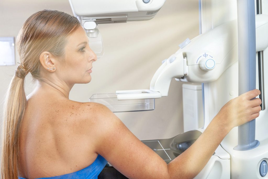 A woman prepares for her screening using advanced medical technology for 3d mammograms houston in a clinic.